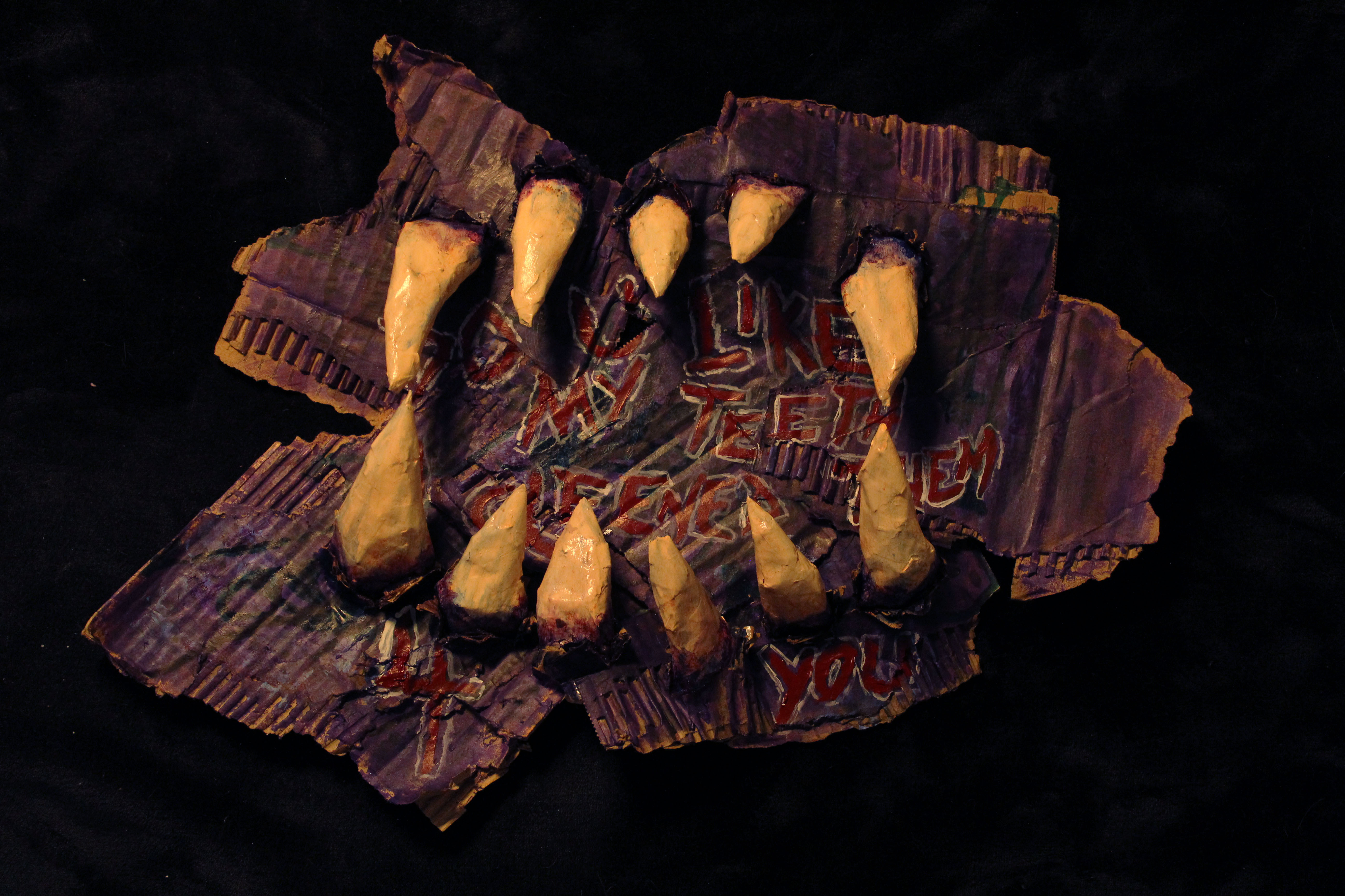 Teeth sprout out of painted cardboard. 